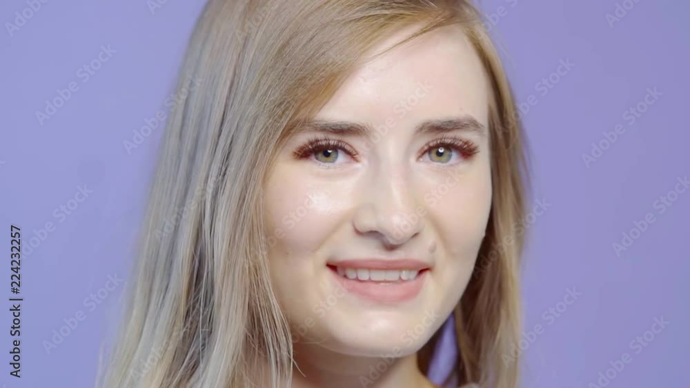 Close-up shot of a fancy blonde model on set, girl isolated on a purple background. Close-up shot of a fancy blonde model on set, girl isolated on a purple background.