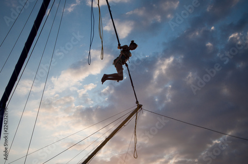 silhouette of a young girl jumping on a bungee on a trampoline on a sunset background on a sea