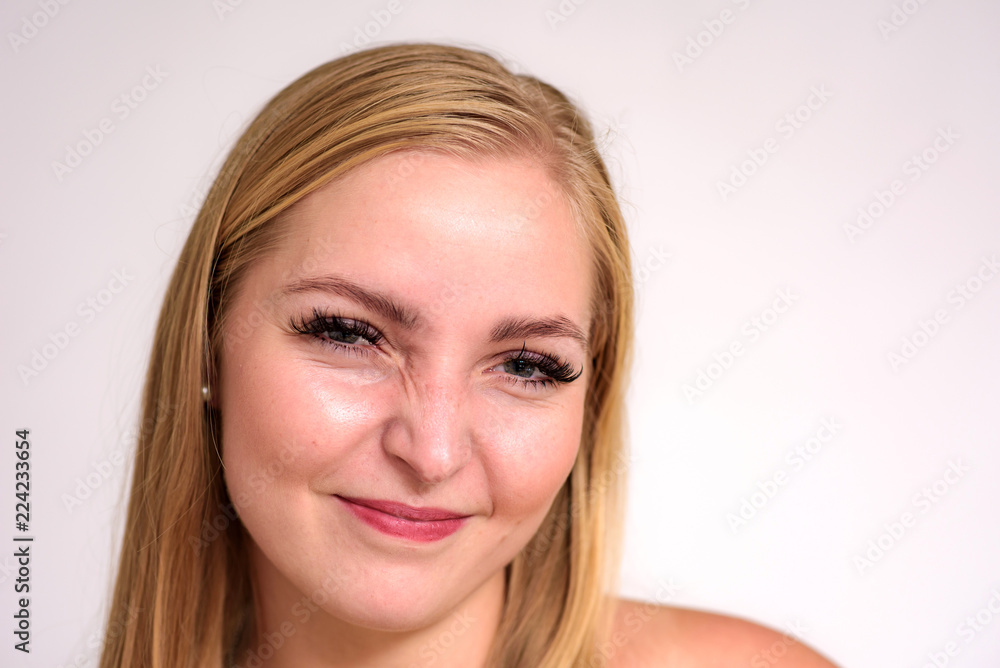 Fototapeta premium Studio portrait of a beautiful blonde girl close-up on a white background in different poses with different emotions