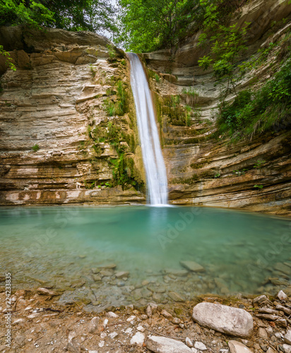 Waterfall and water in mountain of Caucasus. Summer landscape with waterfall and water stream in forest of Caucasus mountain.