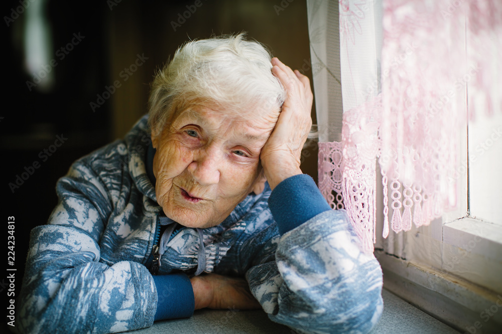 Portrait of elderly woman in the house sitting at the table. Portrait of elderly woman in the house sitting at the table.
