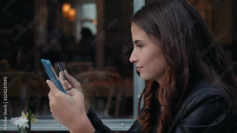 Young woman holding credit card and using laptop computer. Online shopping concept in modern cafe happy brunette girl student tourist on vacation Young woman holding credit card and using laptop computer. Online shopping concept in modern cafe happy brunette girl student tourist on vacation