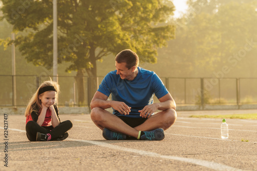Dad and daughter go in for sports.Dad and daughter at the stadium.