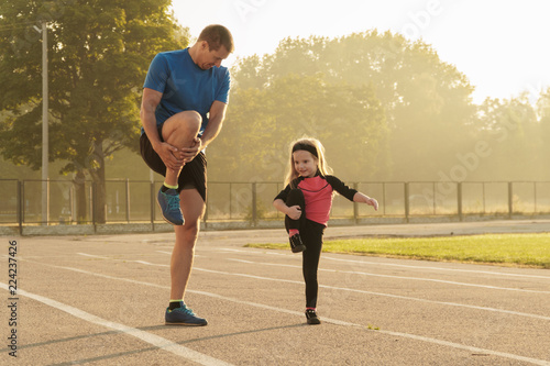 Dad and daughter go in for sports.Dad and daughter at the stadium.