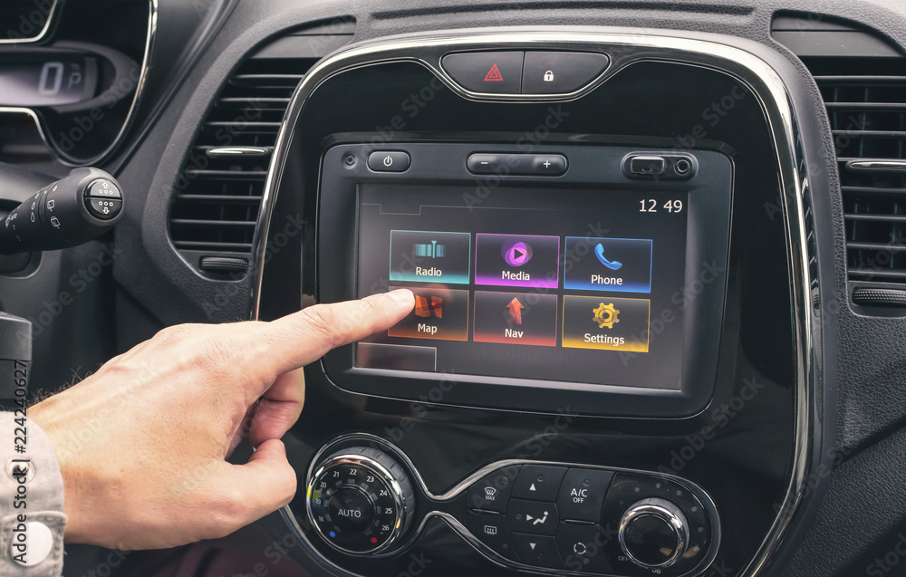 Male hand selects a map on a multimedia system in the car