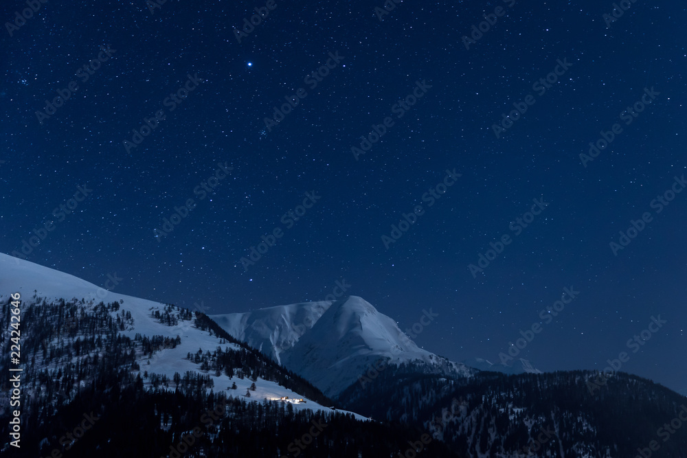 Verschneite Berghütte unter klarem Sternenhimmel