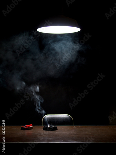 Burning cigarette in interrogation room photo