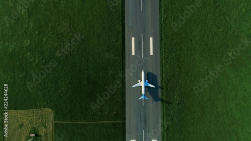 Aerial view of the airplane on take-off approach at the airport runway. top view