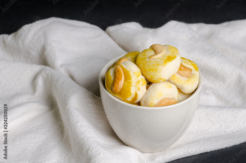 Close up cookies with cashew nut in a white cup. Close up cookies with cashew nut in a white cup.