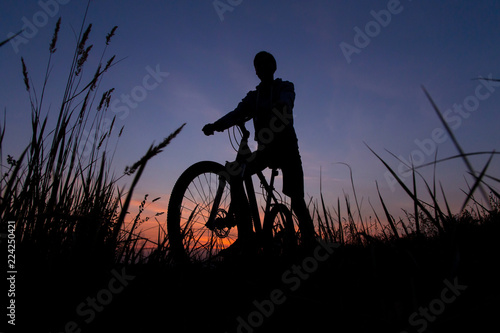 Silhouette of of man cyclist on bike, bicycle against the sunset sky