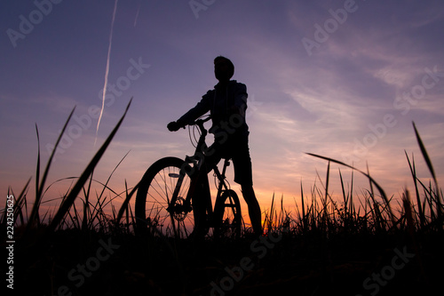Silhouette of man cyclist on bike, bicycle against the sunset sky