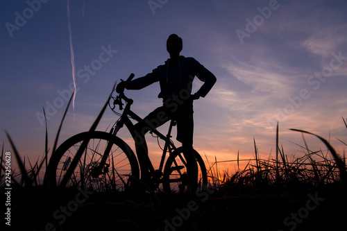 Silhouette of man cyclist on bike, bicycle against the sunset sky