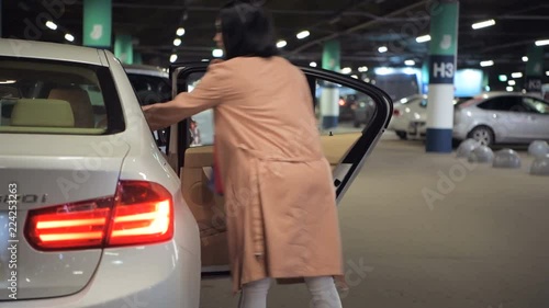 Wallpaper Mural Woman put shopping bags to backseat of her car at underground parking at mall Torontodigital.ca