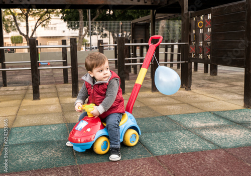 baby with a toy car in a park