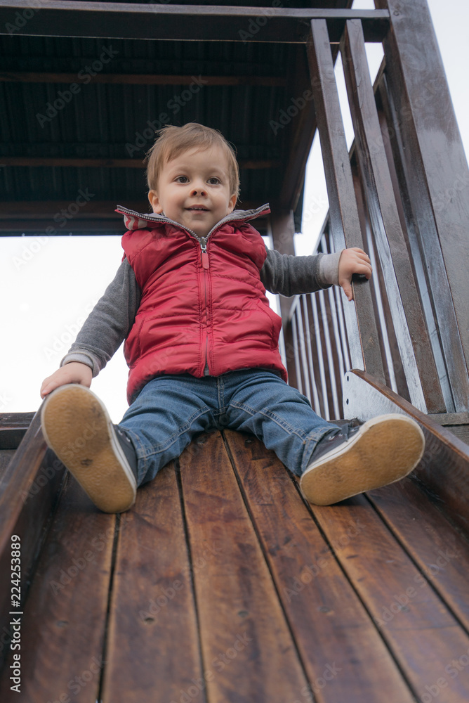 Naklejka premium baby boy in a park at the playground