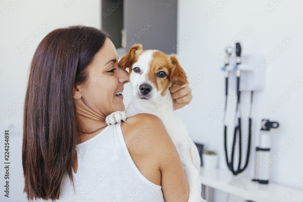 woman holding her healthy dog in a clinic woman holding her healthy dog in a clinic