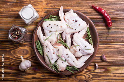 Chicken raw wings with rosemary , garlic , pepper and salt