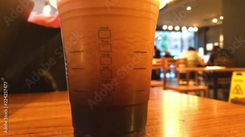 Upwards tilting reveal of a foamy nitro cold brew coffee at a Starbucks venue