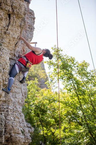 Photo of athlete girl clambering over rock