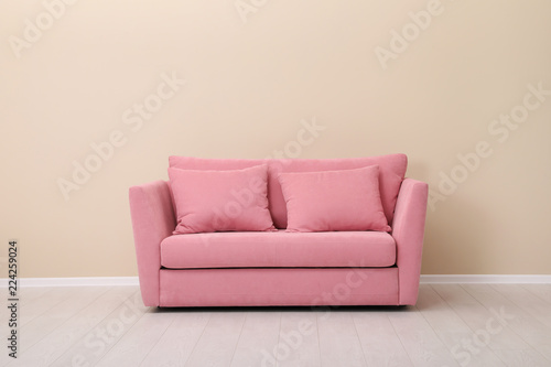 Room interior with comfortable sofa near color wall