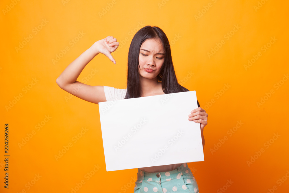 Young Asian woman show thumbs down with white blank sign. Young Asian woman show thumbs down with white blank sign.