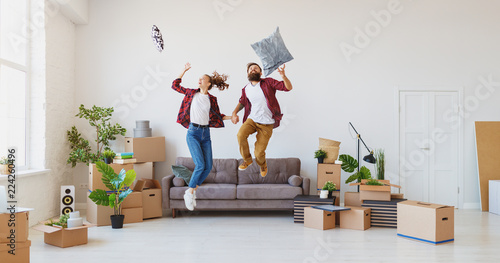 happy young married couple moves to new apartment and laughing,  jump, fight pillows photo