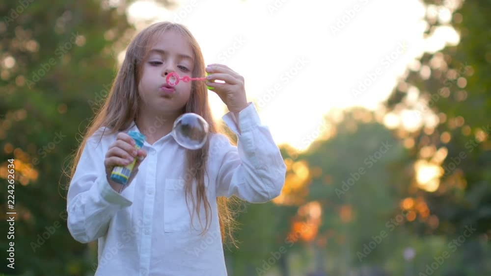 Beautiful girl in the evening park having fun and letting bubbles, children's games Beautiful girl in the evening park having fun and letting bubbles, children's games