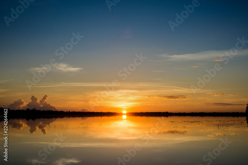 Sunset in the lake. beautiful sunset behind the clouds above the over lake landscape background. dramatic sky with cloud at sunset