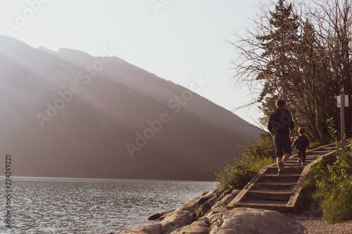 Man and child walking up steps next to a lake