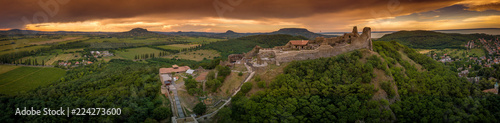 Aerial sunset panorama of ruined medieval Szigliget castle in Hungary above the Lake Balaton with orange yellow sky photo