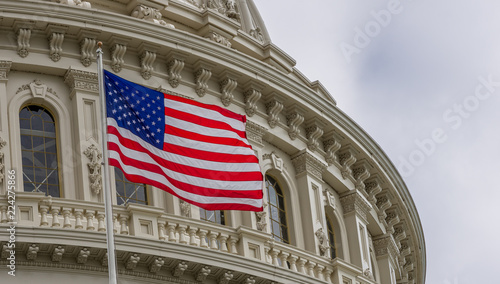 United States Capital building with waving American flag in Washington DC with light blue sky