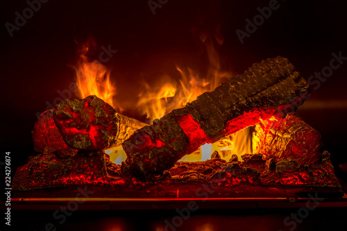 Burning logs with yellow, orange, red flames in a fire place in New York