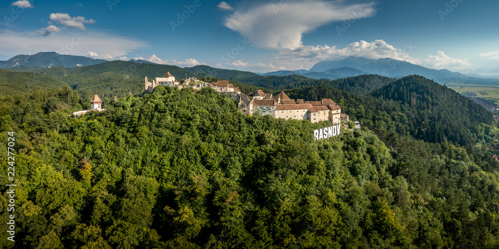 Aerial panorama of Rasnov ruined medieval castle in Transylvania Romania with towers, bastions, walls, barbican and medieval festival