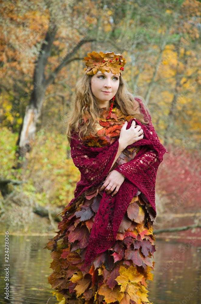 beautiful forest fairy in clothes of leaves hiding in a thick autumn Bush beautiful forest fairy in clothes of leaves hiding in a thick autumn Bush