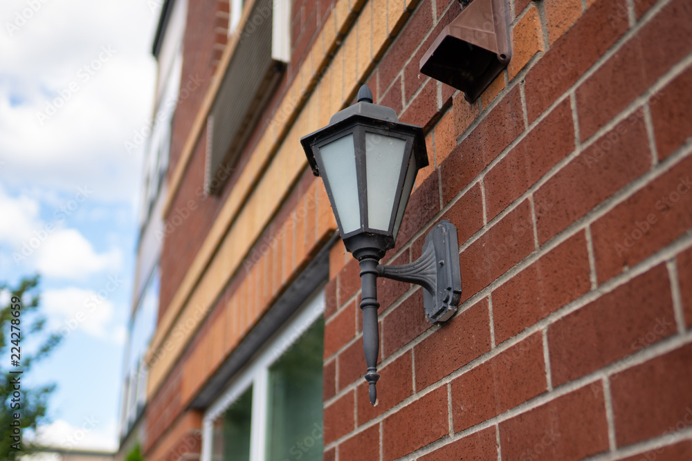 Street lamp on the side of the red brick building in the new modern luxury neighborhood.