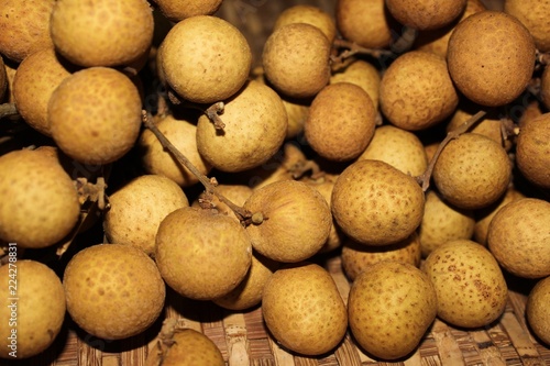 Longan fruits or Dimocarpus longan or Dragon eye fruit on the wooden wicker.