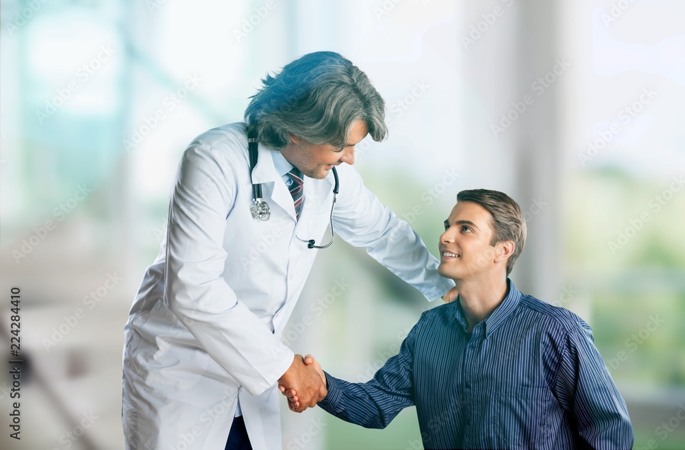 Friendly Senior doctor handshaking with young patient Friendly Senior doctor handshaking with young patient