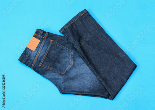 Folded in half men's blue jeans on blue background. The view from the top. Flat lay. photo