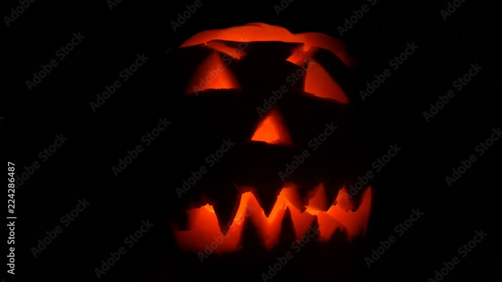 Luminous grimace carved on the Halloween pumpkin to the Day of All Saints in dark Luminous grimace carved on the Halloween pumpkin to the Day of All Saints in dark