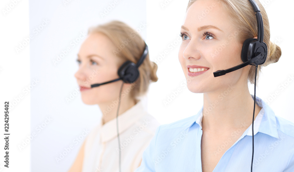 Bright call center office. Two blonde women in a headset Bright call center office. Two blonde women in a headset