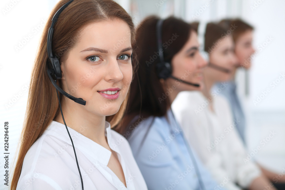 © rogerphoto - Call center. Beautiful cheerful smiling operator consulting clients with headset. Business concept of customer service