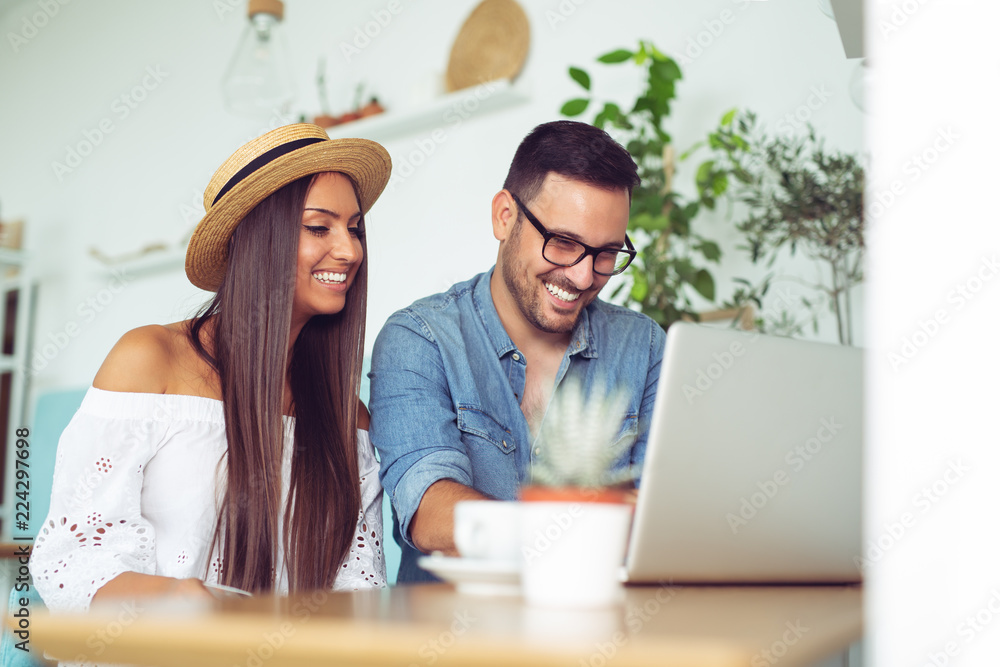 Smiling couple looking at laptop screen indoors Smiling couple looking at laptop screen indoors