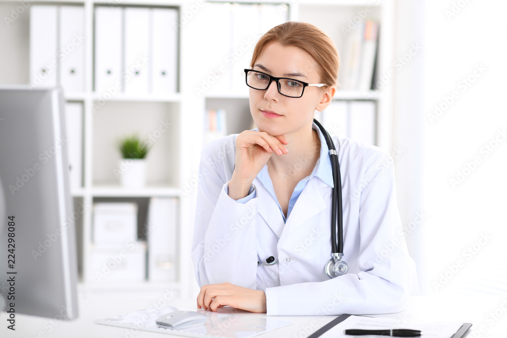 Young brunette female doctor at work in hospital.  Physician ready to help. Medicine and healthcare concept