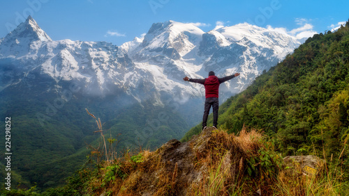 Photography Male tourist stand on a hill top with arms spread overlooking the Himalayan mountain range at North Sikkim India