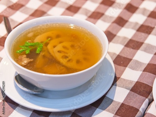 Chinese Lotus Root soup in a white bowl on red checked Pattern tablecloth