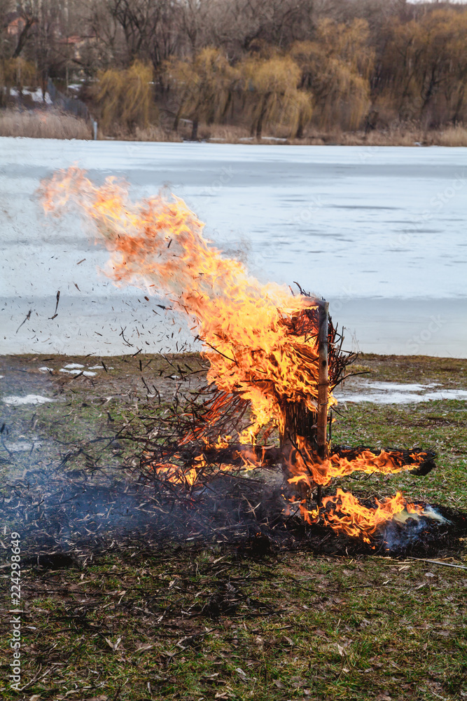 On bank of river burns straw stuffed carnival On bank of river burns straw stuffed carnival