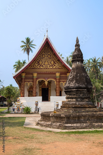 Old and aged chedi or stupa in front of the Buddhist Wat Aham Temple in Luang Prabang, Laos, on a sunny day.