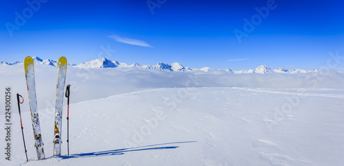 Narty w sezonie zimowym, góry i sprzęt narciarski na szczycie w słoneczny dzień we Francji, w Alpach ponad chmurami.