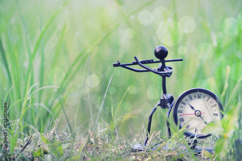 Retro clock with a unique violin statue with green bokeh background Retro clock with a unique violin statue with green bokeh background