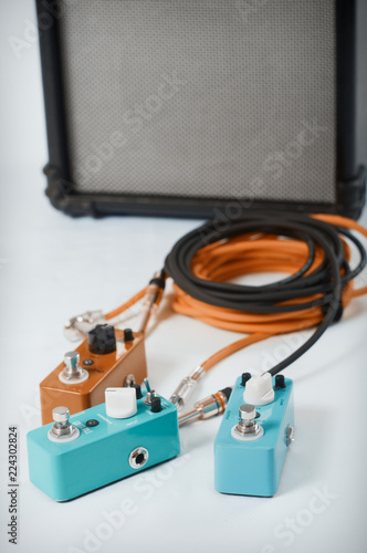 Electric guitar stomp effectors and cables in studio. Focus is on forehand switch box. photo